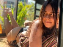 Alessandra Negrini toma sol de biquni pela janela de casa